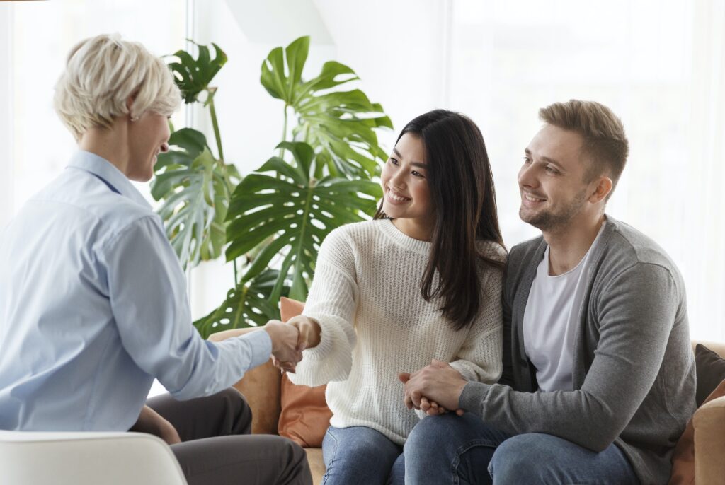 Couple shaking hands with counselor