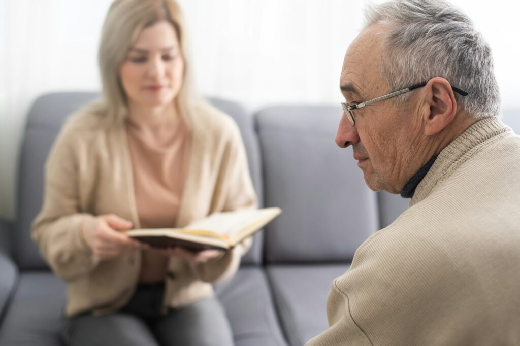 Close up anxious serious old man listening to female doctor at meeting in hospital, therapist