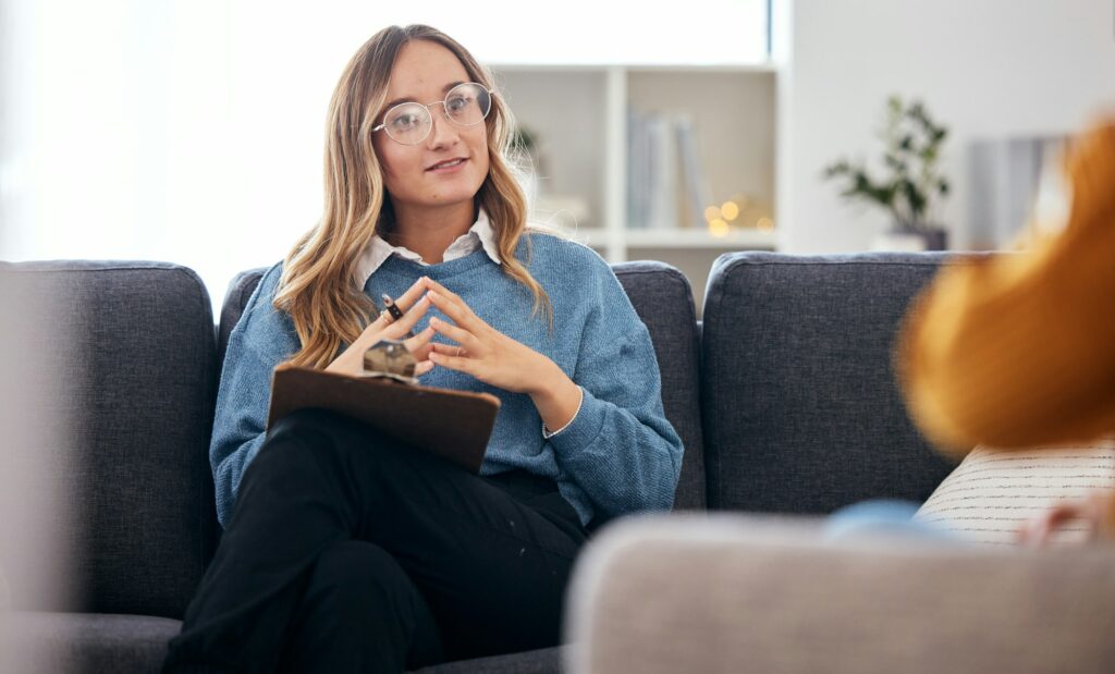 Counseling, therapy and woman therapist talking to client in a consultation or counseling conversat