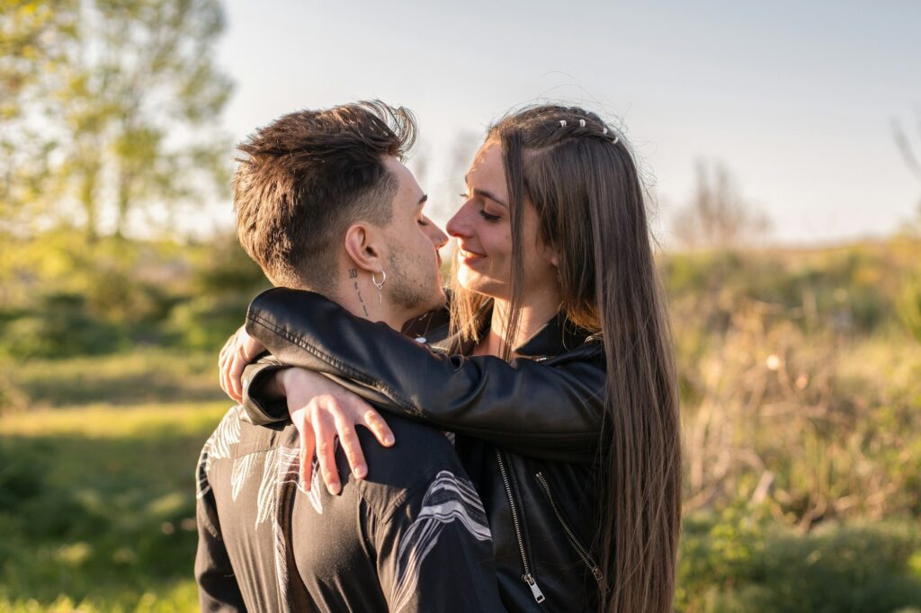 Couple face to face approaching to kiss in field