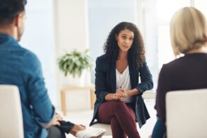 Shot of a young therapist speaking to a couple during a counseling session