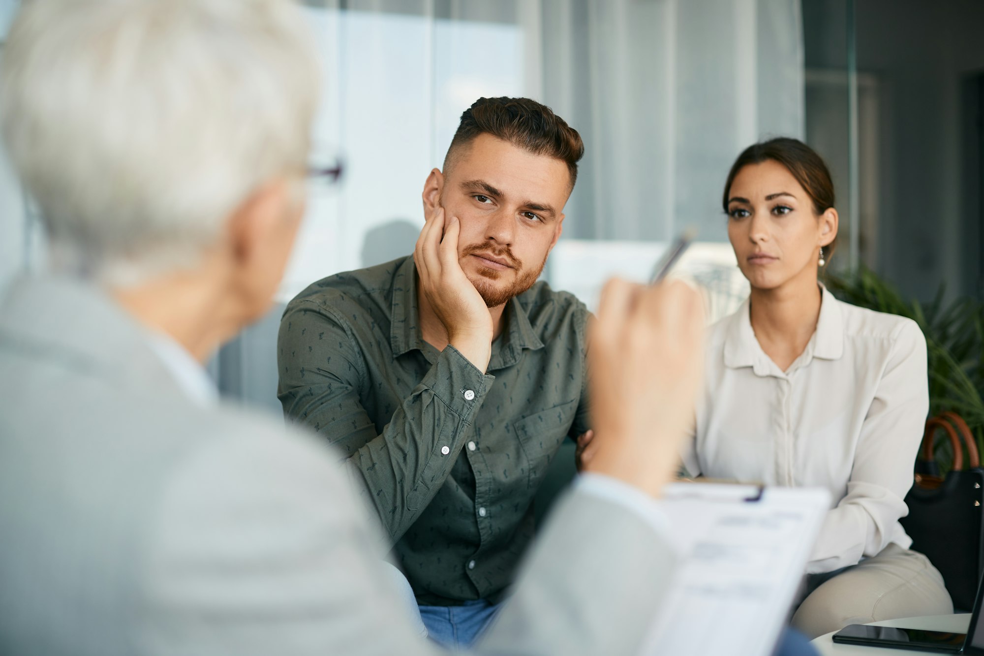 Young couple having marriage counseling with their therapist in the office.