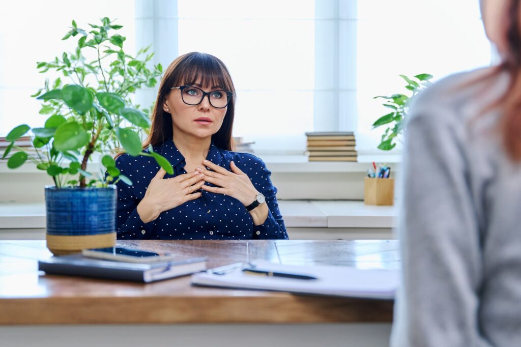 Mature sad woman in therapy session with mental professional